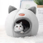 Lit chat hiver confortable avec un chat à l'intérieur, doux et cosy, parfait pour les nuits hivernales.