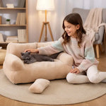 Panier de luxe pour chat avec un chat gris confortablement installé sur un fauteuil en peluche beige.